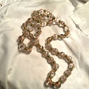 Pink glass beads with pink cloth going through them 36”